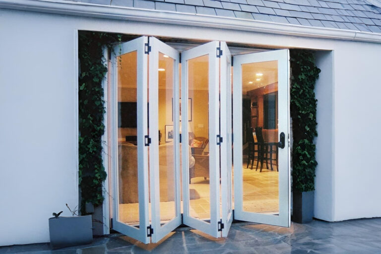 Pintu lipat aluminium putih minimalis untuk akses taman belakang rumah di Jakarta Selatan.